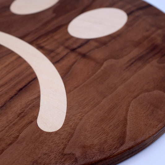 sad face cutting board made of walnut